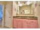 Charming bathroom with dual sinks, pink cabinetry, and a large decorative mirror at 2816 Ivy Lake Ct, Lakeland, FL 33811