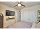 This bedroom features carpet, a ceiling fan, double door closet, and a TV on the wall at 2816 Ivy Lake Ct, Lakeland, FL 33811