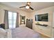 This is a bedroom with carpet, a ceiling fan, a dresser with a mirror, and a television on the wall at 2816 Ivy Lake Ct, Lakeland, FL 33811