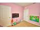 Pink bedroom with a television and a door to the closet at 2816 Ivy Lake Ct, Lakeland, FL 33811
