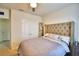 This bedroom features a button tufted headboard, carpet, and neutral colored bedding at 2816 Ivy Lake Ct, Lakeland, FL 33811