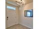 Inviting entryway with modern lighting, a decorative mirror, and neutral tile flooring at 2816 Ivy Lake Ct, Lakeland, FL 33811