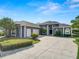 Inviting house with mature trees, colorful landscaping, and long driveway leading to a three-car garage at 2859 Medinah Cir, Lakeland, FL 33803