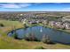 Scenic aerial view of a community with a central pond, a fountain, and surrounding lush greenery at 3019 Mission Lakes Dr, Lakeland, FL 33803