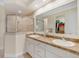 Bright bathroom featuring double sinks, granite countertops, glass enclosed shower, and a large walk-in closet at 3019 Mission Lakes Dr, Lakeland, FL 33803