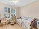 Bedroom featuring wood floors, a ceiling fan, and a large window with plantation shutters at 3019 Mission Lakes Dr, Lakeland, FL 33803