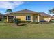 Charming yellow home with well-manicured lawn and attractive landscaping under a bright blue sky at 3019 Mission Lakes Dr, Lakeland, FL 33803