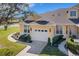 View of a home's facade with a two-car garage, landscaped yard, and manicured lawn at 3019 Mission Lakes Dr, Lakeland, FL 33803