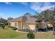 Charming yellow home with manicured landscaping, showcasing a welcoming entrance and attached garage at 3019 Mission Lakes Dr, Lakeland, FL 33803