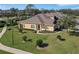 Aerial view of charming yellow home with a large lawn and mature trees at 3019 Mission Lakes Dr, Lakeland, FL 33803