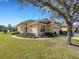 Charming yellow home with a well-manicured lawn and mature landscaping on a sunny day at 3019 Mission Lakes Dr, Lakeland, FL 33803