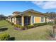 View of the yellow stucco house with a screened lanai and landscaped yard at 3019 Mission Lakes Dr, Lakeland, FL 33803