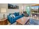 Cozy living room features a comfortable blue couch, a natural wood coffee table, and sliding glass doors to the lanai at 3019 Mission Lakes Dr, Lakeland, FL 33803