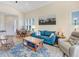 Bright living room with natural light, featuring a blue sofa, rocking chair and mountain themed artwork at 3019 Mission Lakes Dr, Lakeland, FL 33803