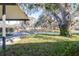 Inviting front yard view with mature trees draped in Spanish moss over a green lawn at 306 Estrella Way, Auburndale, FL 33823