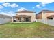 Spacious backyard with lush lawn, privacy fence, covered patio, and outdoor seating area at 3460 Canvas St, Kissimmee, FL 34741