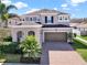Charming two-story home featuring a brick driveway, a two-car garage, and well-maintained landscaping at 3460 Canvas St, Kissimmee, FL 34741