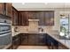 Modern kitchen with dark cabinets, granite countertops, and stainless-steel appliances at 3460 Canvas St, Kissimmee, FL 34741