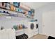 Functional laundry room with washer, dryer, storage shelves, and sink area at 3460 Canvas St, Kissimmee, FL 34741