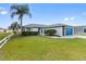 Charming single-story home featuring a manicured lawn, palm tree, and vibrant blue garage door at 3719 Imperial Dr, Winter Haven, FL 33880
