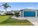 A well-kept single-Gathering home featuring a blue garage door and green lawn at 3719 Imperial Dr, Winter Haven, FL 33880
