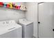 Functional laundry room with washer, dryer, and shelving for storage at 3719 Imperial Dr, Winter Haven, FL 33880