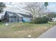 Backyard view featuring a screened-in porch, grassy lawn, and mature trees providing shade at 403 Saint Anns Dr, Winter Haven, FL 33884