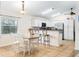 Bright eat-in kitchen with stainless steel appliances, white cabinetry, tile backsplash, and a breakfast bar at 403 Saint Anns Dr, Winter Haven, FL 33884