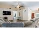 Open living room featuring tile floors, a ceiling fan, and a large television at 403 Saint Anns Dr, Winter Haven, FL 33884