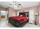 Cozy main bedroom featuring a large black bed and plush red bedding at 403 Saint Anns Dr, Winter Haven, FL 33884