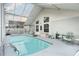Bright indoor pool with screen enclosure, offering a refreshing retreat, plus seating at 403 Saint Anns Dr, Winter Haven, FL 33884