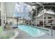 Indoor pool with screen enclosure, next to the spa, with seating and room to relax at 403 Saint Anns Dr, Winter Haven, FL 33884