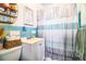 Well-maintained bathroom with blue tiling, clean fixtures, and a modern shower curtain at 424 S Elm Rd, Lakeland, FL 33801