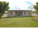 Rear exterior with a covered patio overlooking the lawn, providing a serene outdoor living space at 4932 St James St, Winter Haven, FL 33881