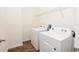 Bright laundry room with wood-look floors, equipped with a white washer and dryer, and a wire shelf at 4932 St James St, Winter Haven, FL 33881