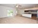 An open-concept living space with a living room and kitchen overlooking a beautiful pond through sliding glass doors at 4932 St James St, Winter Haven, FL 33881