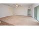 A spacious living room featuring neutral carpet, a ceiling fan, and sliding glass doors leading to the backyard at 4932 St James St, Winter Haven, FL 33881