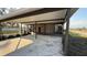 View of the spacious outdoor carport featuring a brick home, screening, and mature landscaping at 495 King St, Haines City, FL 33844
