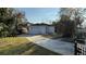 View of detached garage featuring a double garage door, white brickwork, and private driveway at 495 King St, Haines City, FL 33844