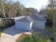 View of detached garage featuring a double garage door, white brickwork, and private driveway at 495 King St, Haines City, FL 33844