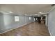 Open-concept living room with wood-look tile flooring and neutral gray walls at 495 King St, Haines City, FL 33844