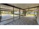 An outdoor patio featuring screening, a ceiling fan, tile floors, and mature landscaping at 495 King St, Haines City, FL 33844