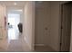 Neutral colored tile hallway leading to living room with neutral colored walls and white doors at 5062 Foxglove Cir, Lakeland, FL 33811