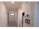 Hallway with tile floor leads to the front door with wall decorations and dog leashes at 5062 Foxglove Cir, Lakeland, FL 33811