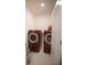 Functional laundry room equipped with front-load washer and dryer units on pedestals at 5062 Foxglove Cir, Lakeland, FL 33811