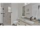 Modern bathroom featuring a stone pebble shower, a marble countertop vanity, and white cabinets at 510 Shanklin Ave, Bartow, FL 33830