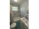 Updated bathroom with white vanity and marble-tiled tub and shower at 515 Crevasse St, Lakeland, FL 33805