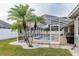 The backyard features small palm trees, and white rocks in front of the screened in lanai at 5155 Lake Deeson Woods Ct, Lakeland, FL 33805