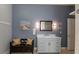 Charming bathroom with a painted vanity with marble countertop, decorative mirror, and a seating bench at 5155 Lake Deeson Woods Ct, Lakeland, FL 33805