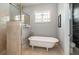 Bright bathroom with a luxurious freestanding tub, stained glass window, and a marble-tiled shower at 5155 Lake Deeson Woods Ct, Lakeland, FL 33805